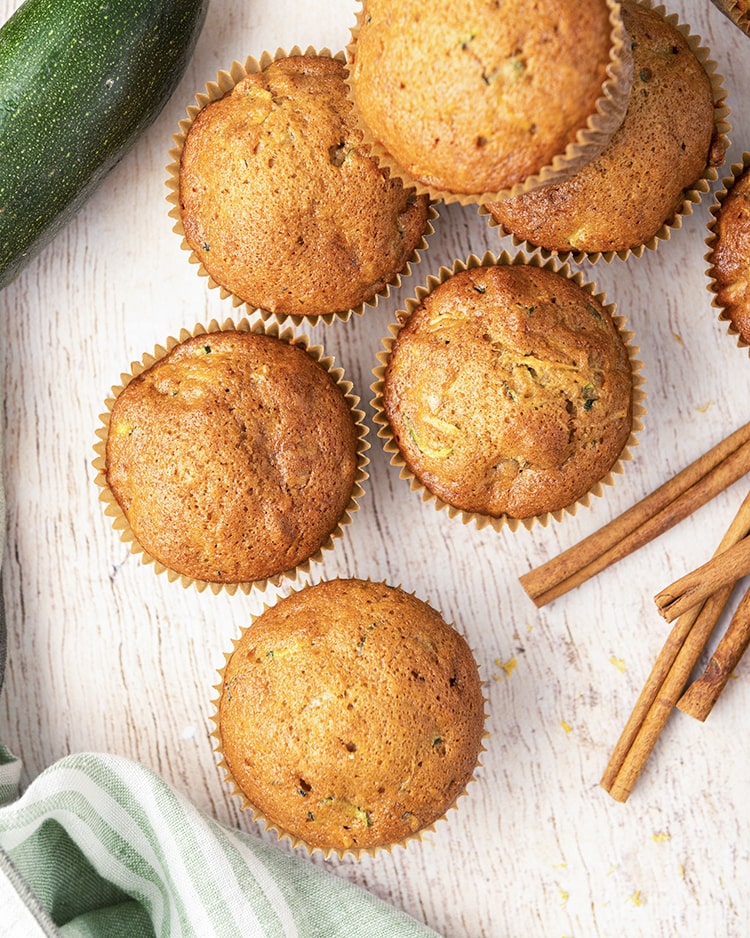 An overhead shot of zucchini muffins on a white background
