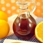 Close up of orange zest syrup in a glass jar.