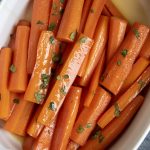 A pile of sweet glazed carrots in a dish.