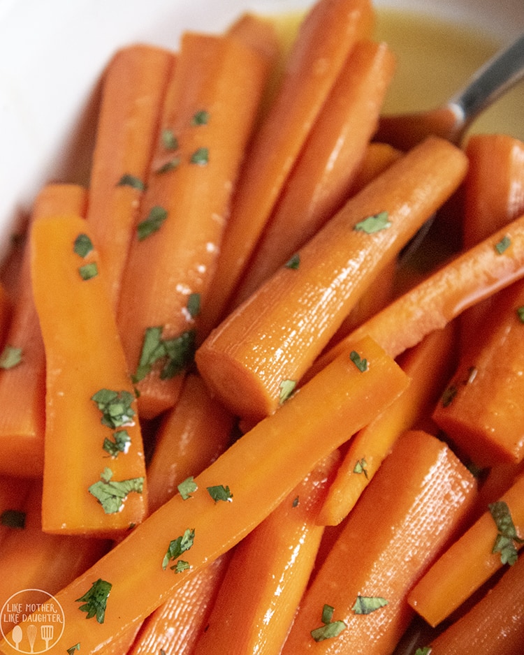 Glazed carrots in a pile topped with fresh parsley.