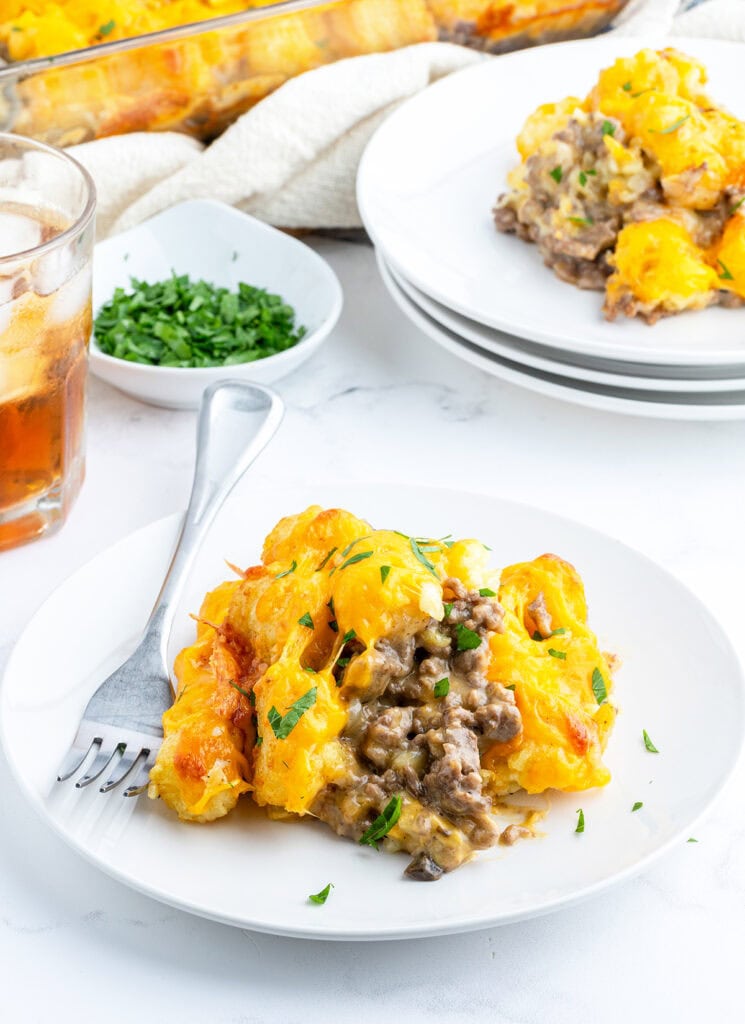 A plate of cheeseburger tater tot casserole next to a fork.