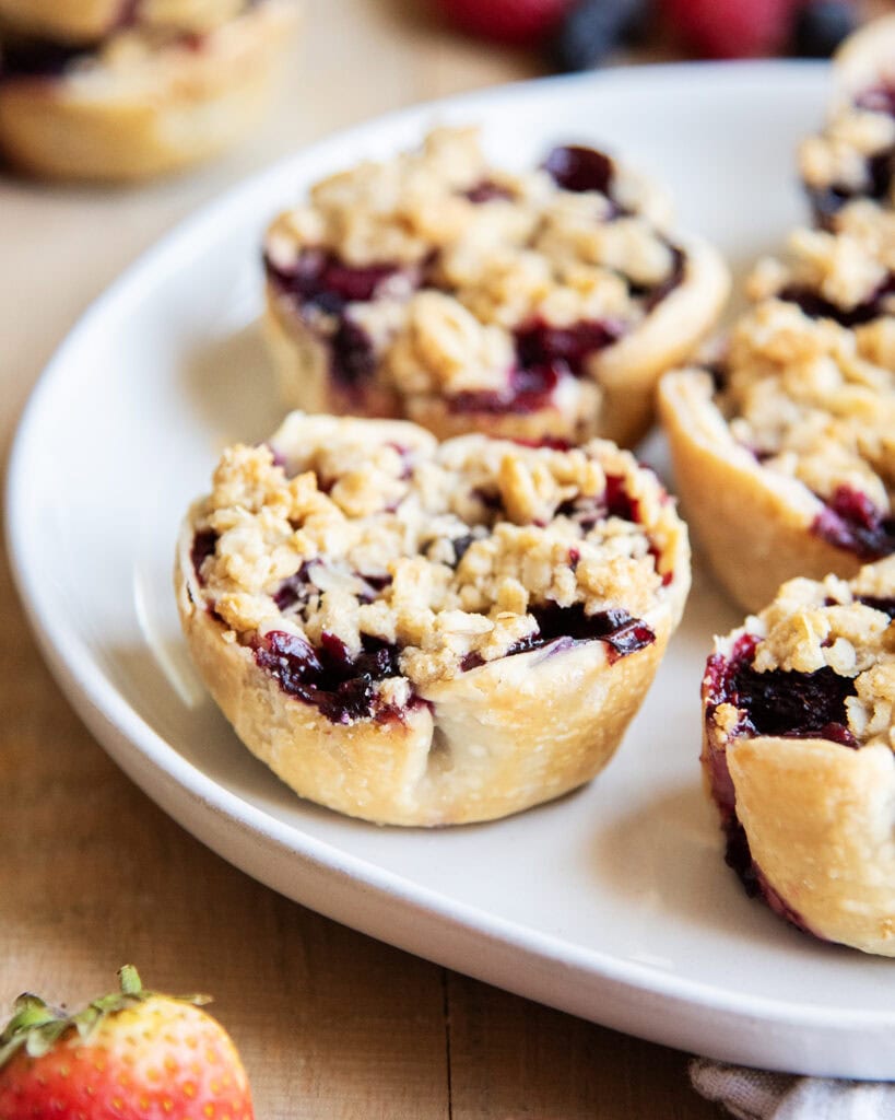 A plate of crumble topped berry mini pies.