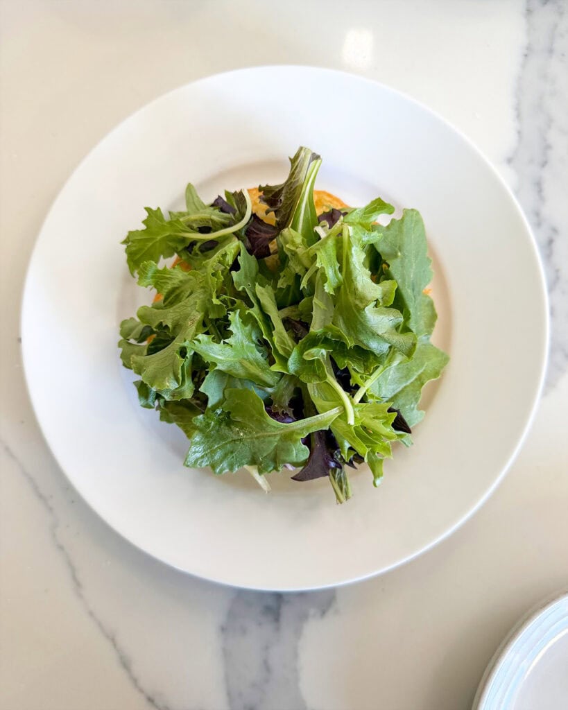 A bun topped with lettuce.