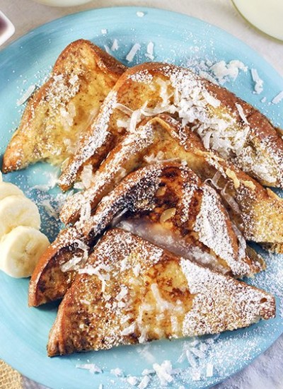 Top view of coconut french toast on a blue plate.