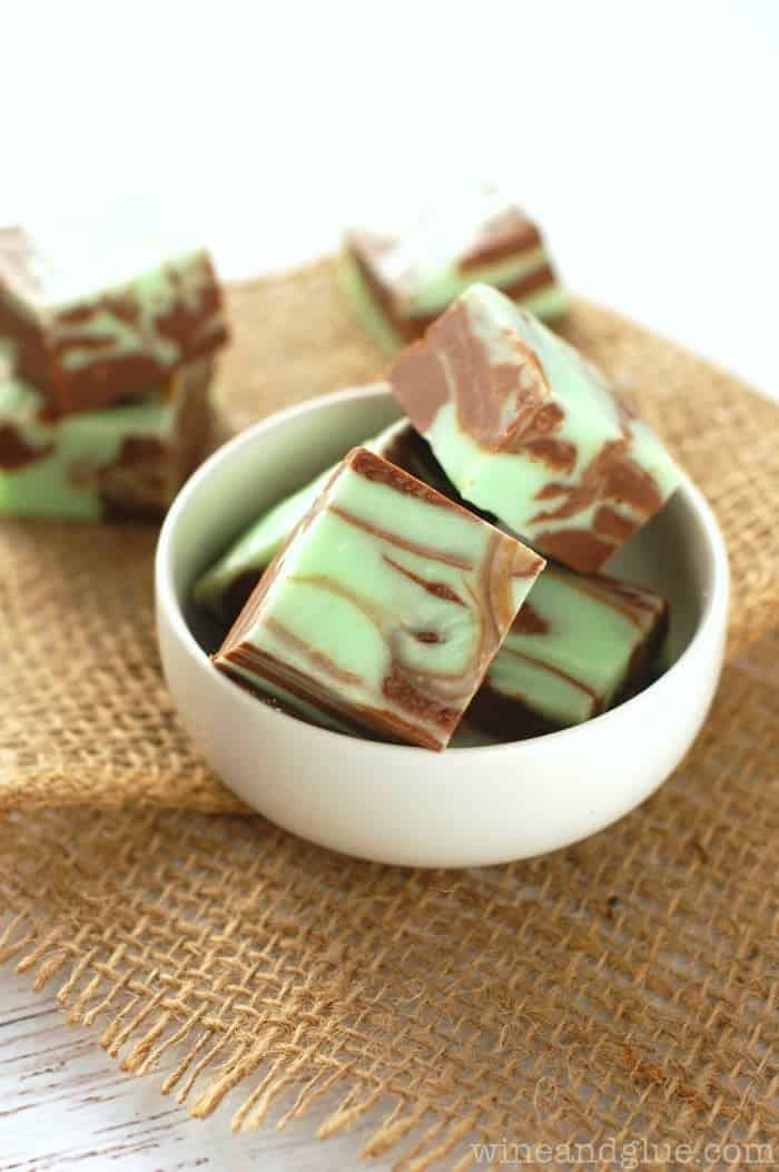 A small bowl filled with pieces of green and chocolate colored swirled fudge.