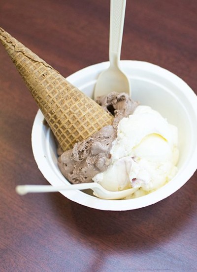 Top view of a bowl of ice cream with a cone and with a spoon.