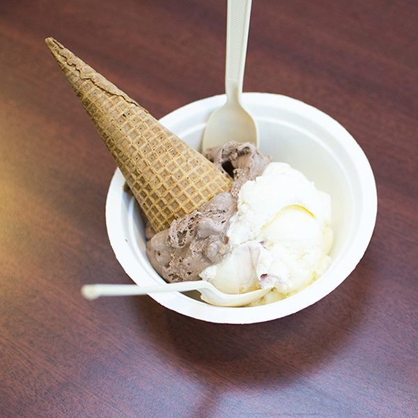 Top view of a bowl of ice cream with a cone and with a spoon.