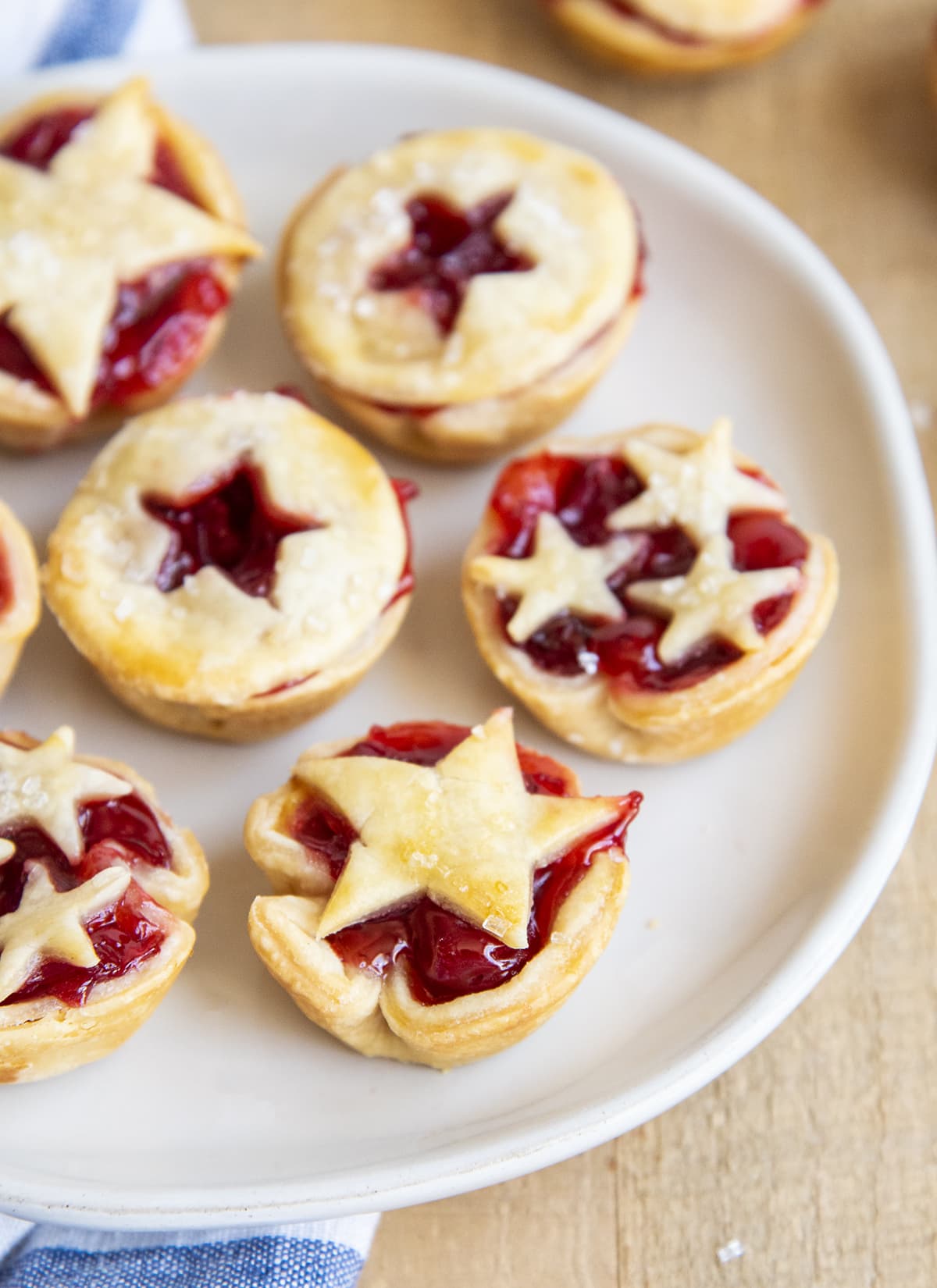 A white plate topped with mini cherry pie bites.