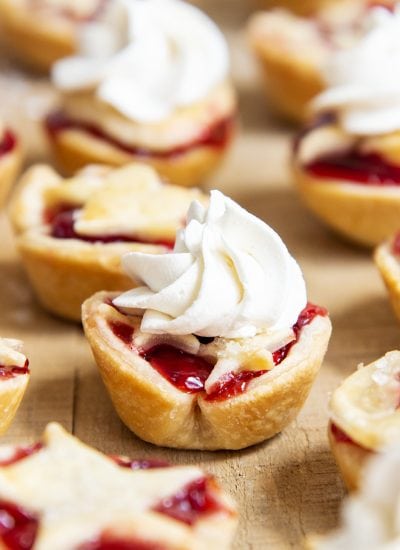 A cherry pie bite topped with whipped cream.