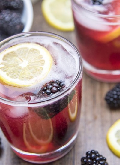 Angled view of blackberry lemonade in glasses.