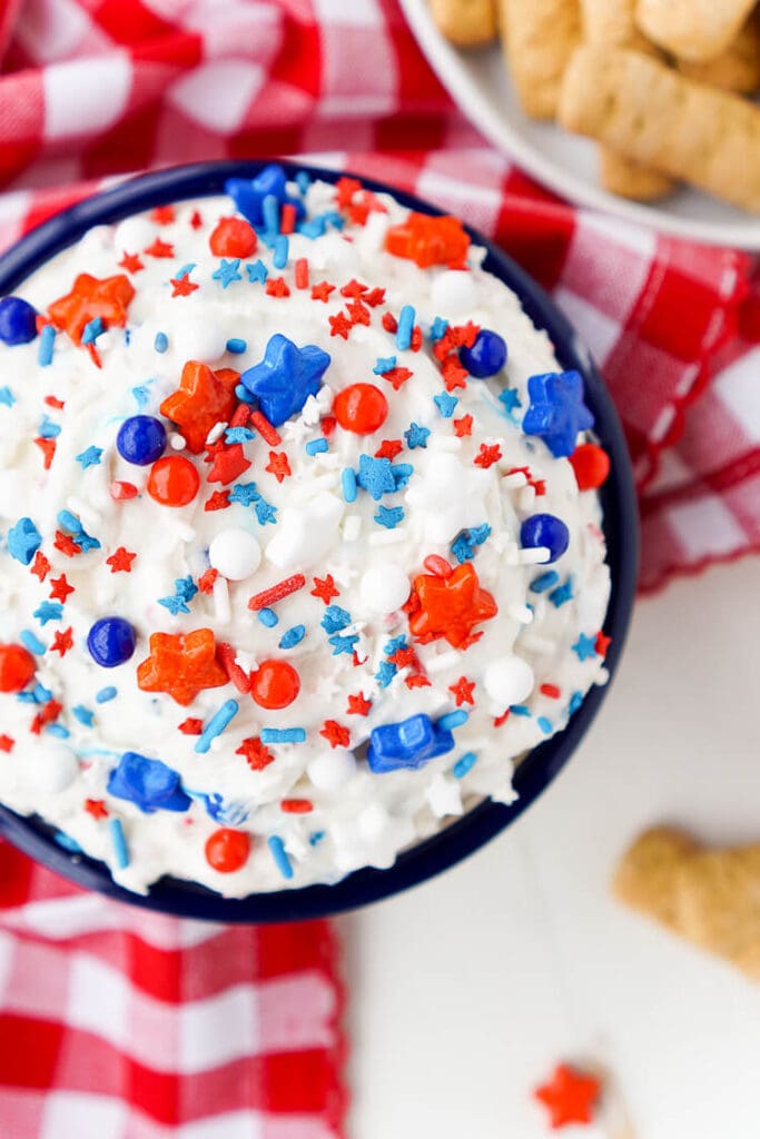 An overhead view of cake batter dip topped with patriotic sprinkles. 