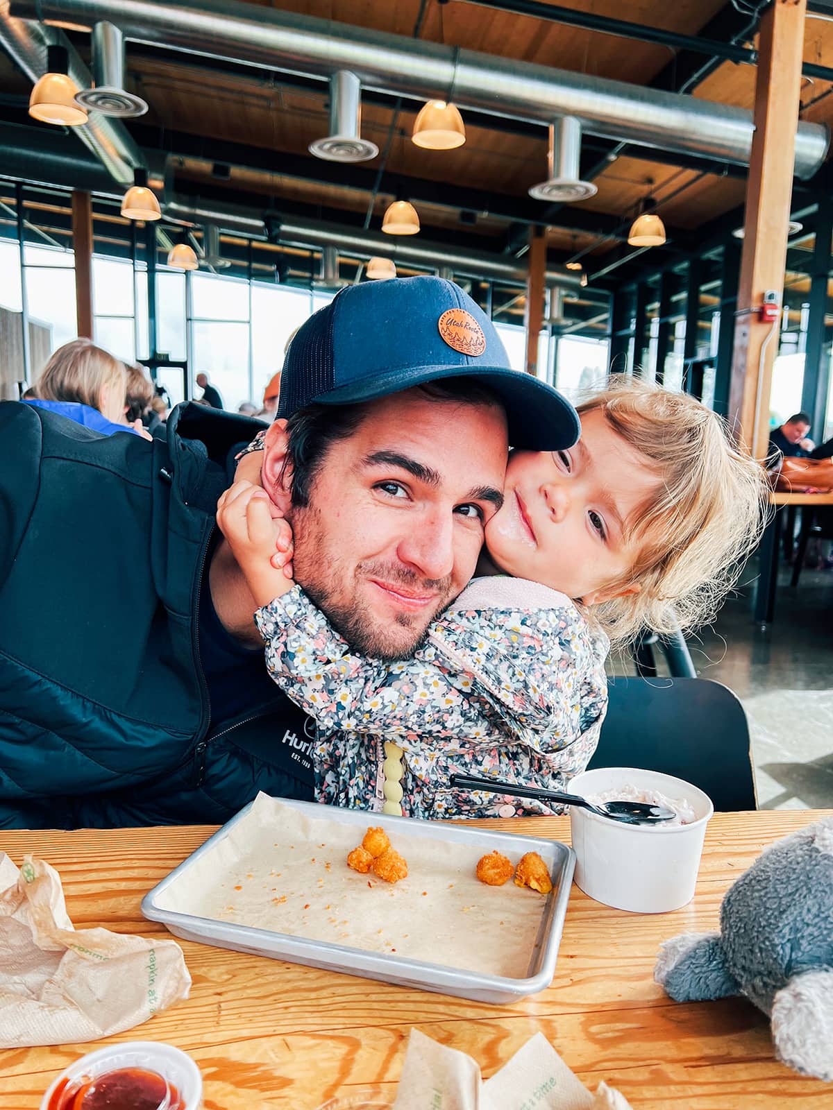 A little girl hugging her dad at the Tillamook Creamery. 