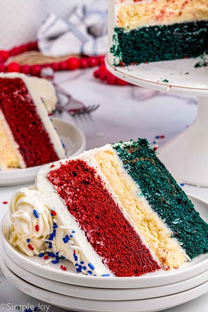 A slice of layered red white and blue cheesecake cake on a plate. 