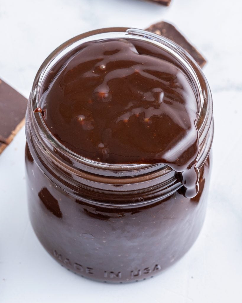 A close up of a jar of chocolate hot fudge sauce.