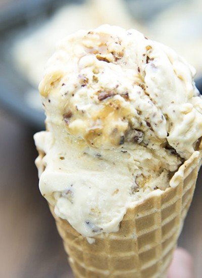 Close up view of salted caramel pecan ice cream in a cone.