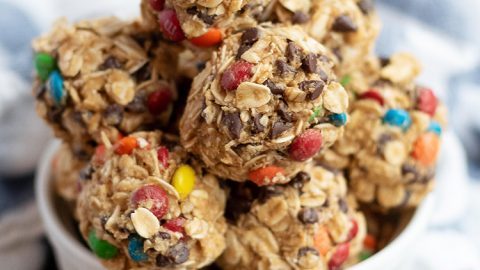 Close up image of monster granola bites with oats and m&m's in a small white ramekin.