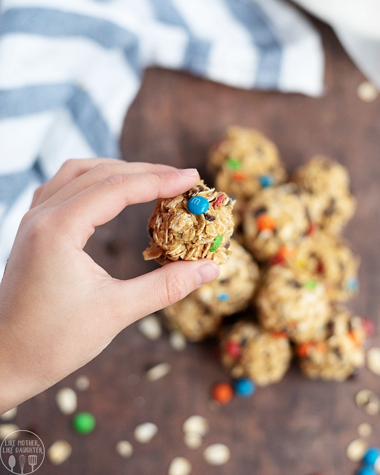 Close up image of a hand holding a single no bake monster cookie granola bite.