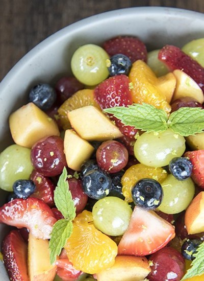 Above view of rainbow fruit salad in a white bowl.