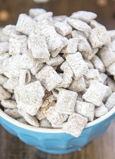 Angled view of scotcheroo muddy buddies in a blue bowl.