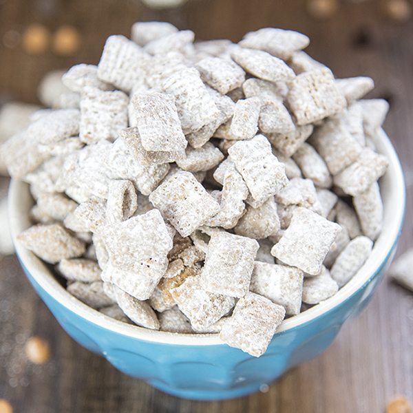 Angled view of scotcheroo muddy buddies in a blue bowl.