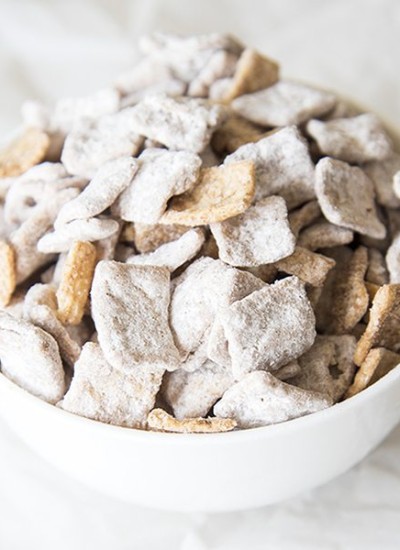 Angled view of snickerdoodle muddy buddies in a white bowl.