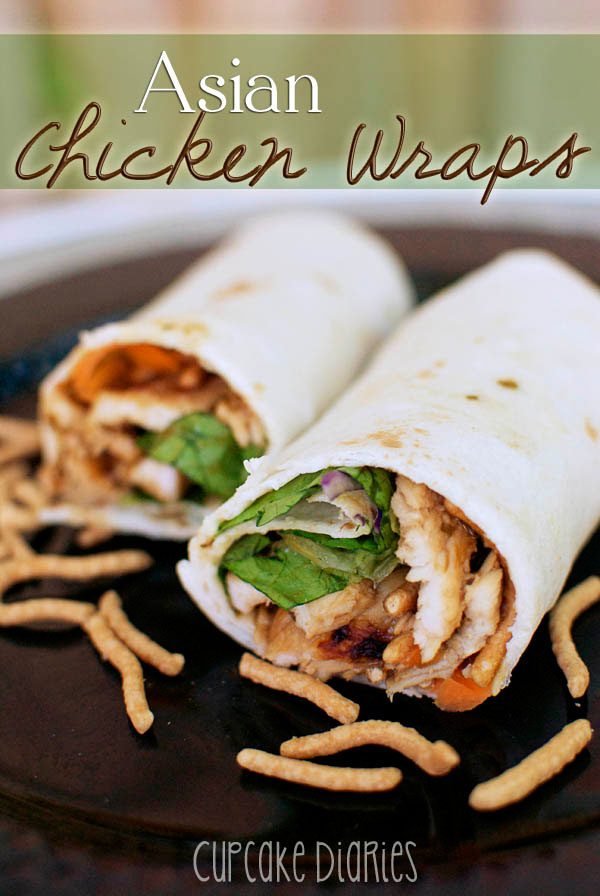 Close up of two sliced asian chicken wraps on a plate.