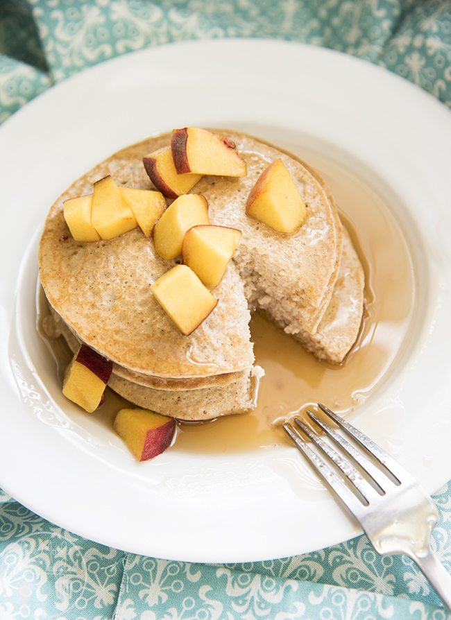 Angled view of biggest loser pancakes stacked on a white plate with a fork.