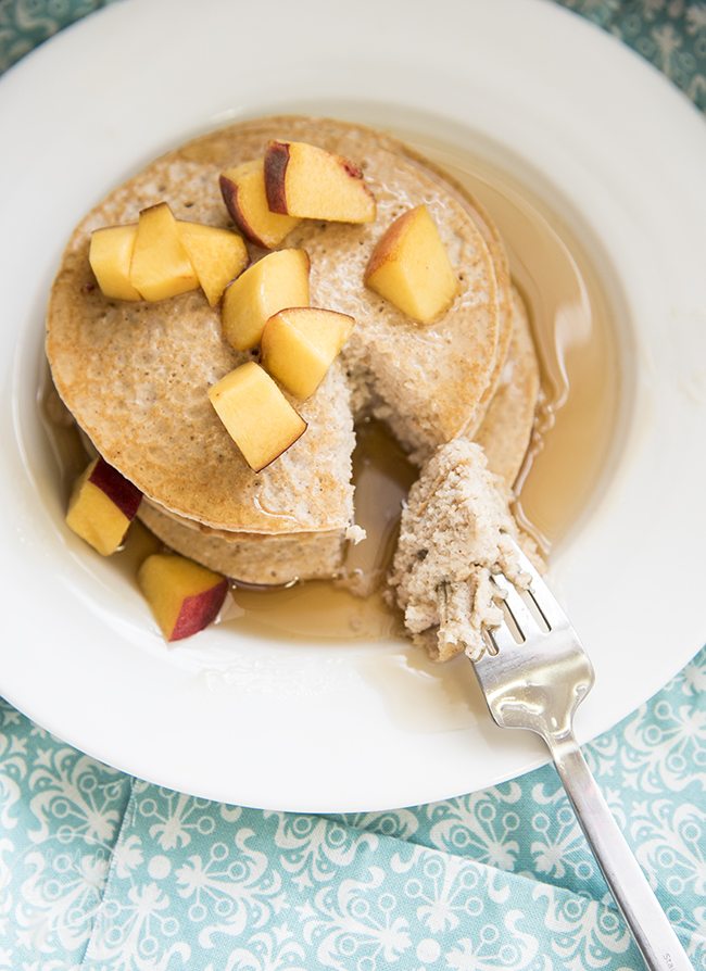 Angled view of biggest loser pancakes stacked on a white plate with a fork cutting a piece out.