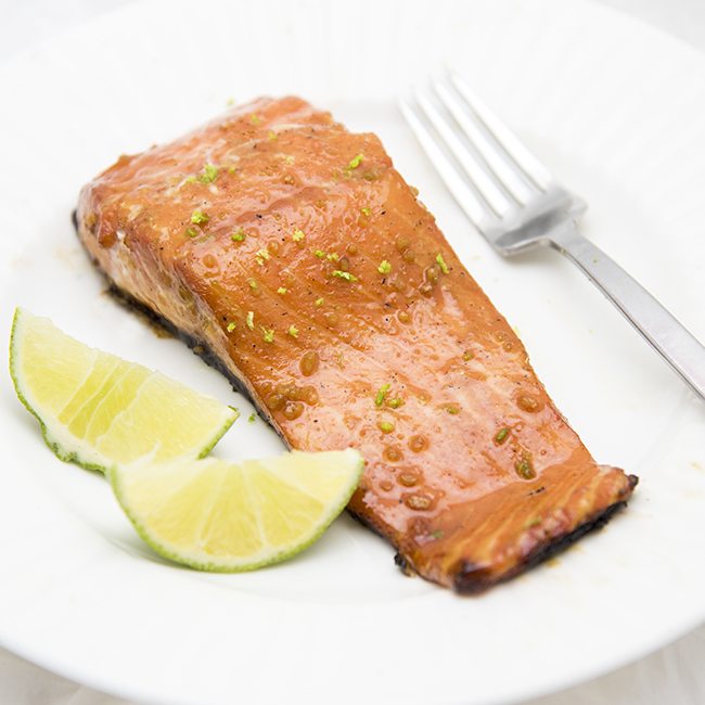 Angled image of honey lime salmon on a small white plate.