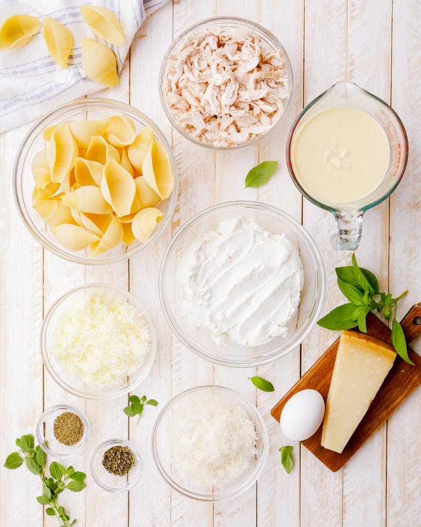 The ingredients needed to make Chicken Alfredo Stuffed Shells: Chicken, Alfredo Sauce, Shells, Ricotta, Parmesan, Mozzarella and Seasonings.