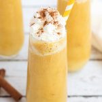 Pumpkin Pie Smoothie in a glass topped with whipped cream and cinnamon.
