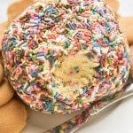 A sprinkle covered cake battery cheeseball is displayed with the middle visible.