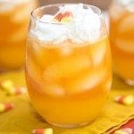 Side view of candy corn layered drink in a glass.