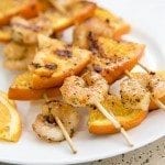 Close up of honey garlic and orange shrimp kebabs on a stick.