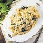 An overhead photo of a platter full of penne and dandelion greens.