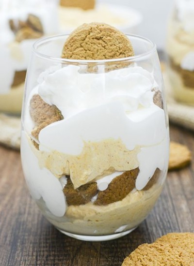 Side view of a pumpkin cheesecake parfait in a glass.