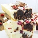 A stack of three pieces of white chocolate, and chocolate swirled pomegranate fudge.