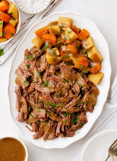 An overhead photo of a platter of 3 packet roast and veggies.