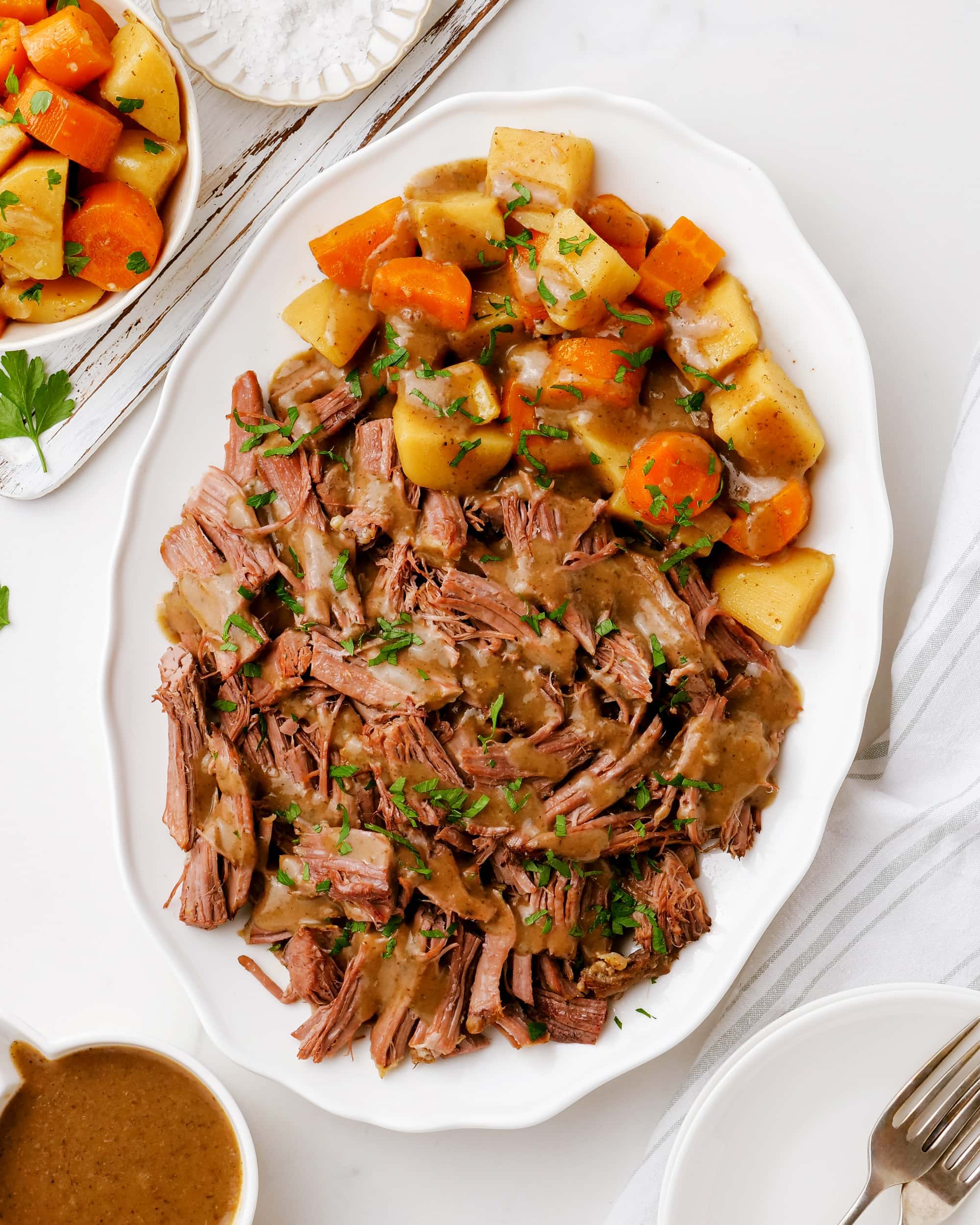 An overhead photo of a platter of 3 packet roast and veggies.