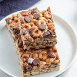 Close up image of chocolate chip fluffernutter cheerio bars stacked on a plate.