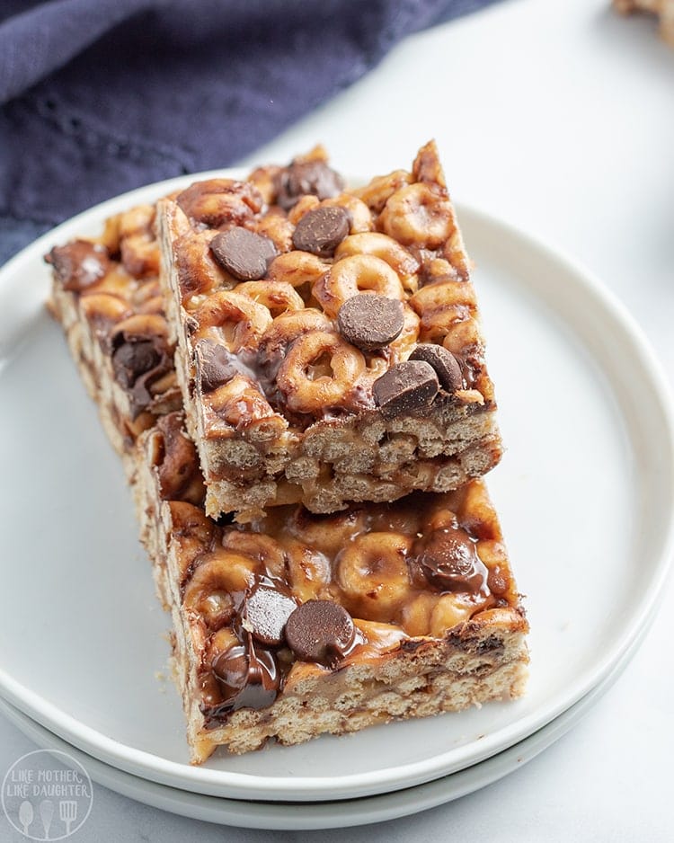 Close up image of chocolate chip fluffernutter cheerio bars stacked on a plate.