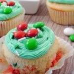 Angled view of festive funfetti cupcakes on a wood board.