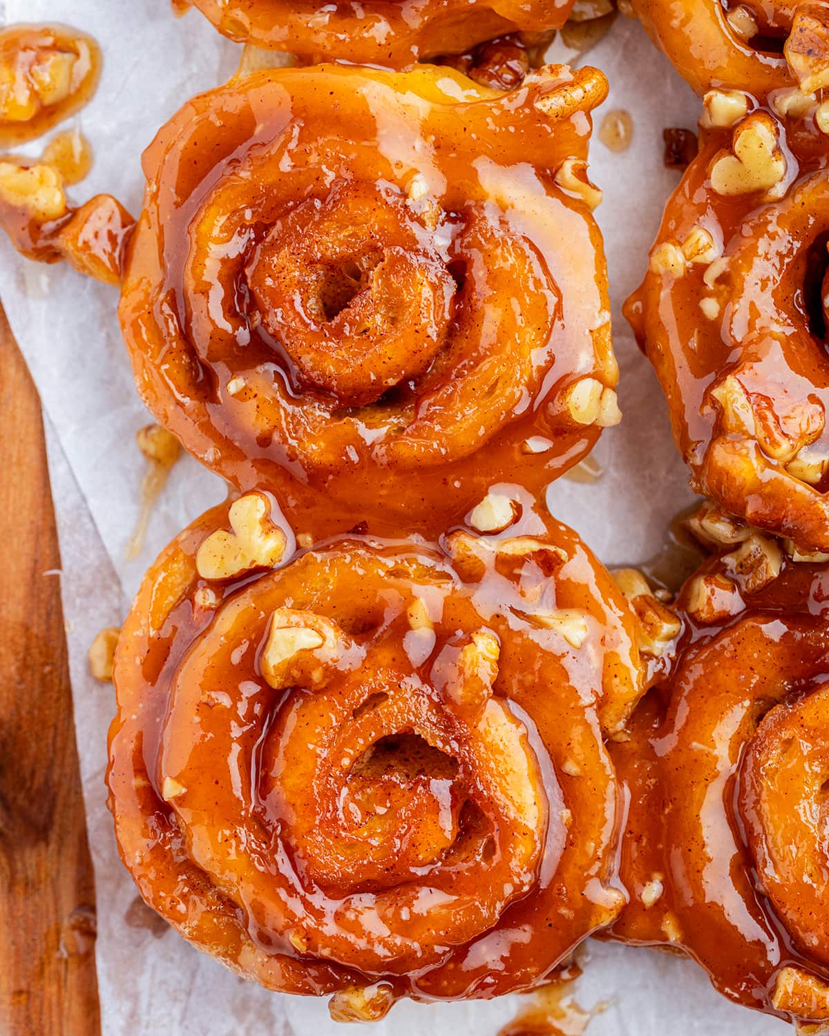 A close up of two mini caramel cinnamon rolls topped with pecans.