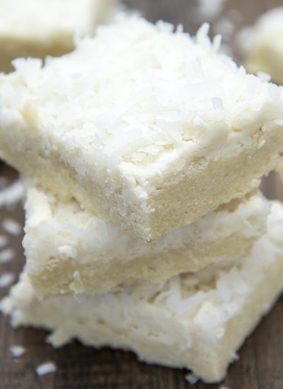 Close up view of coconut sugar cookie bars stacked on top of each other.