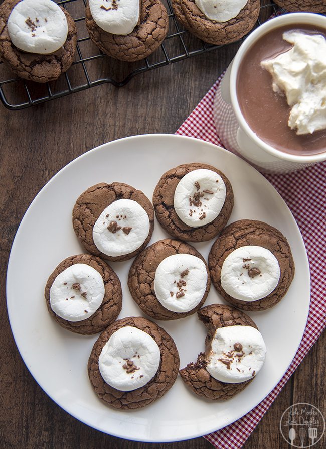 Above view of hot chocolate cookies on a white plate with hot chocolate next to it.