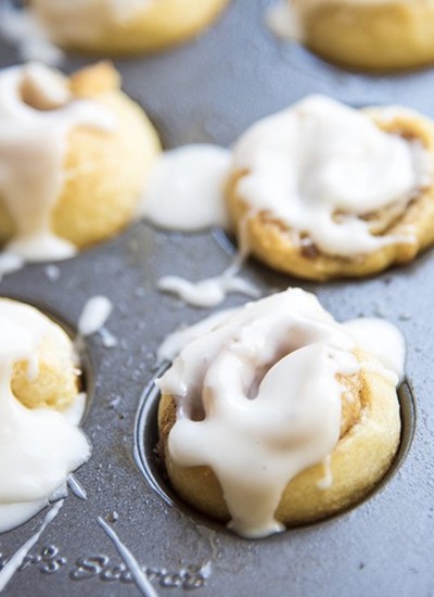 Close up view of mini cinnamon rolls in a baking pan.