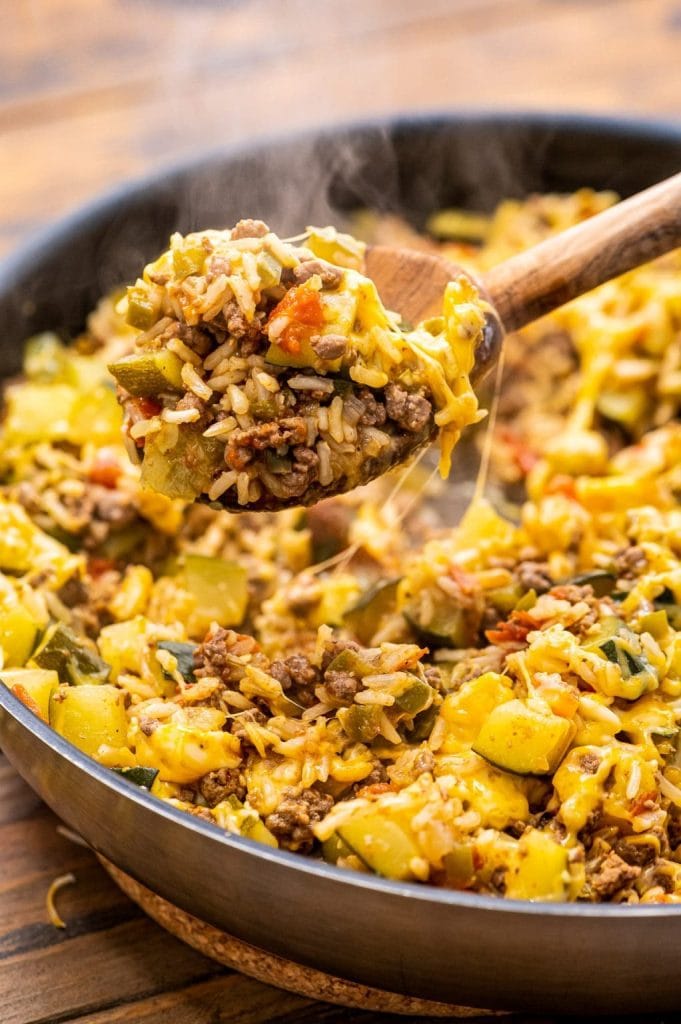 A skillet loaded with rice, ground beef, zucchini, and tomatoes.