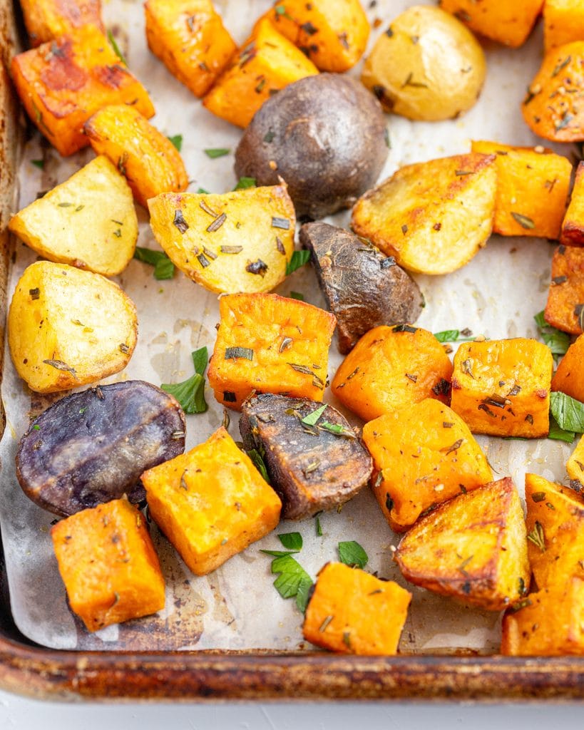 A close up of roasted sweet potatoes on a baking pan.
