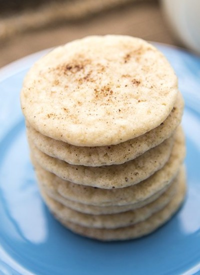 Angled view of stacked eggnog cookies on a blue plate.