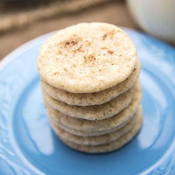 Angled view of stacked eggnog cookies on a blue plate.
